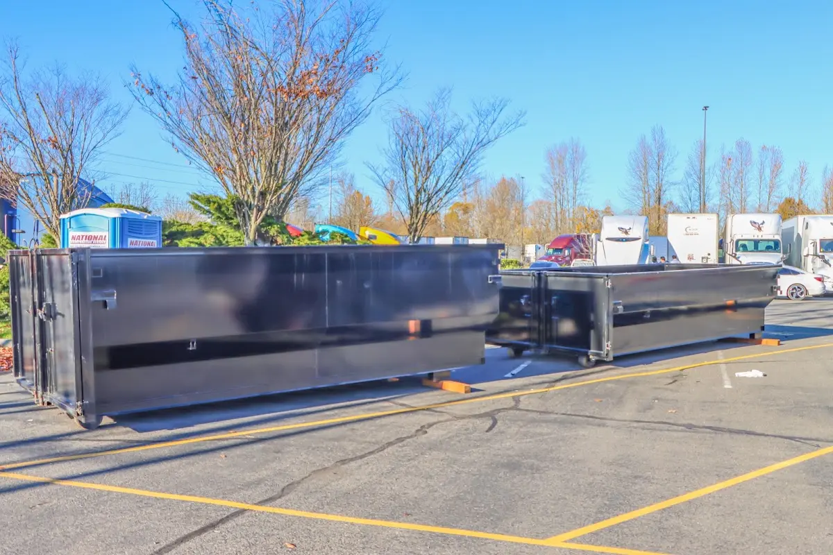 Professional dumpster rental service with roll-off container on residential driveway in Bellefonte